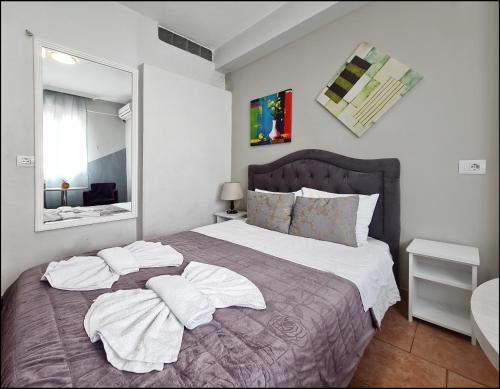 a bedroom with a large bed with towels on it at Guest House De Rada in Tirana