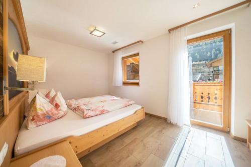 a small bedroom with a bed and a window at Fewo Sonnenuntergang - Zeppichl in Pfelders