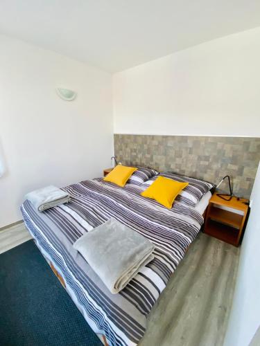 a large bed with yellow pillows in a room at Apartmány na Horce in Blata
