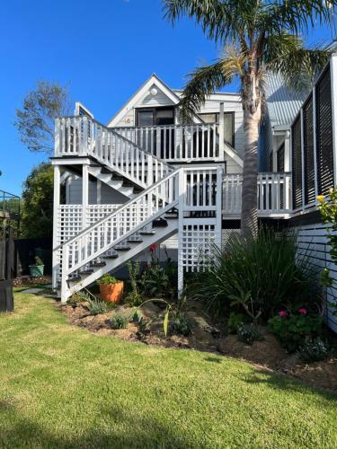 a house with a white staircase next to a palm tree at The Jazz Loft in Onetangi