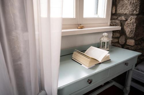 a table with a book and a candle and a window at Dionysos Hotel in Poros