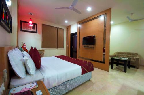 a hotel room with a bed and a television at Hotel Metropolitan in New Delhi