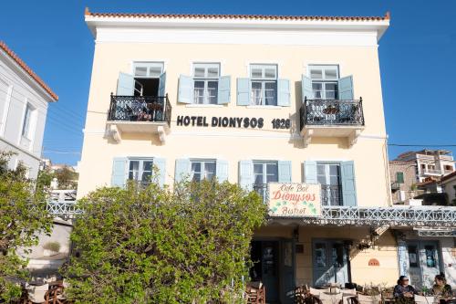 a white building with a sign that reads hotel dunoshenko at Dionysos Hotel in Poros