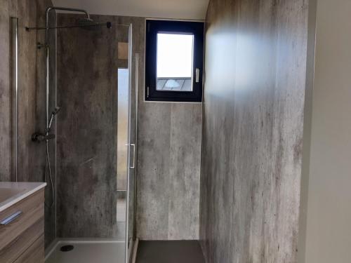 een badkamer met een douche en een glazen deur bij Tiny house XXL in Bant