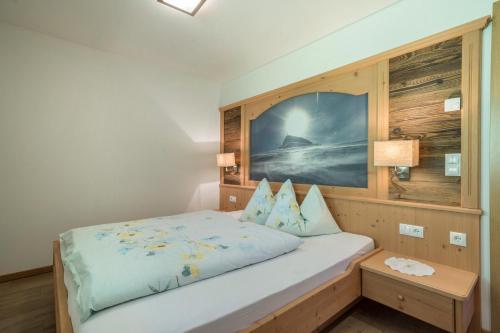 a bedroom with a bed with a wooden wall at Fewo Sonnenaufgang - Zeppichl in Pfelders