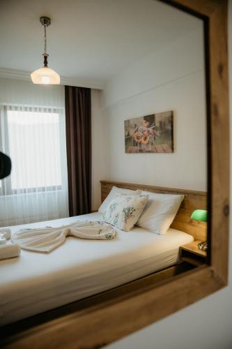 a bedroom with a large bed with a mirror on it at Azra Apart & Otel in Gokceada Town