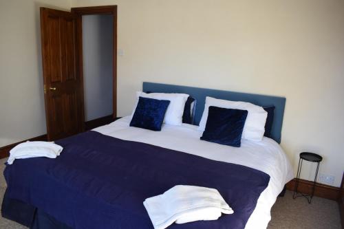 un grande letto con lenzuola e cuscini blu e bianchi di Lovely 2 bedroom duplex apartment, Maidstone sleeps 5 a Kent