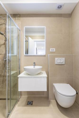 a bathroom with a sink and a toilet and a mirror at Blue Pearl Apartment in Cres
