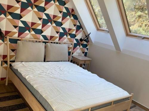 een slaapkamer met een bed met een geometrische muur bij Modern Holiday Home in Kamień with a View and Garden in Kamień