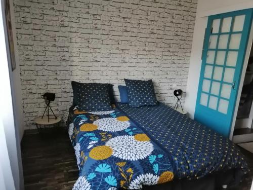 Cama en habitación con pared de ladrillo en La maison de 6Fran appartement 1 calme et spacieux ambiance familiale, en Valros