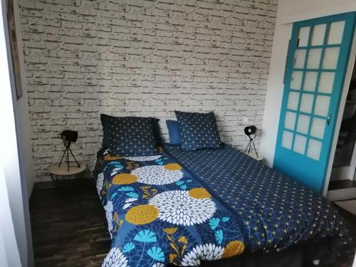 a bed in a room with a brick wall at La maison de 6Fran appartement 1 calme et spacieux ambiance familiale in Valros