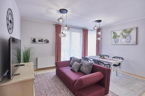 salon z fioletową kanapą i stołem w obiekcie Apartamenty Świnoujście - Zacisze Leśne w Świnoujściu