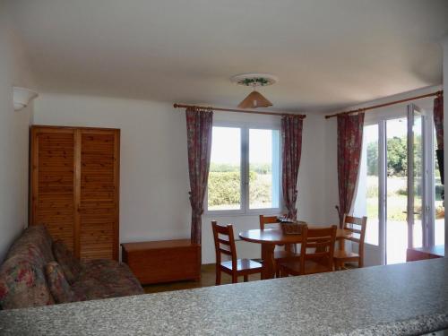 a living room with a couch and a table and chairs at Séjour à la campagne pour 6 in Commequiers