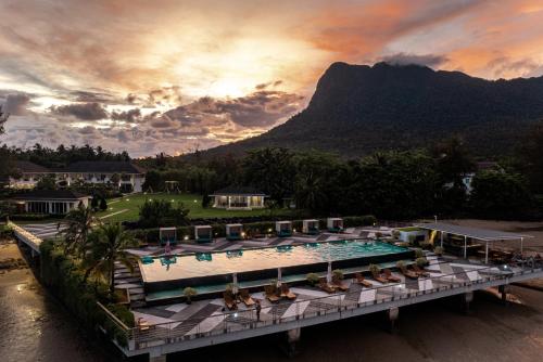 a resort with a pool and a mountain in the background at Cove 55 in Santubong