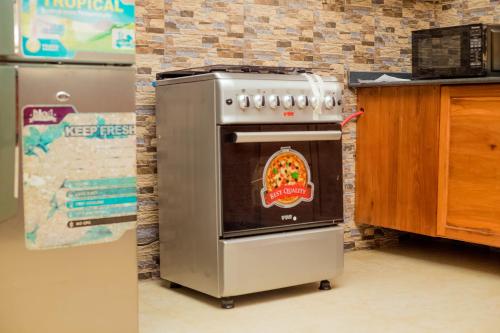 a kitchen with a stove with a pizza on it at Randa Family House - Moshi in Himo