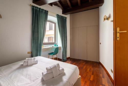 una camera da letto con un letto bianco e asciugamani di Maison Leonardo al Pantheon a Roma