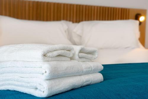 a pile of towels sitting on top of a bed at Aqua Apartments Bellamar, Marbella in Marbella