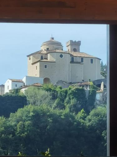 a building on top of a hill with trees at Hotel Edelweiss in Laino Borgo