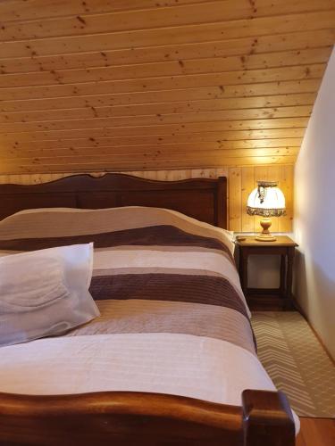 a bedroom with a bed with a wooden ceiling at Holiday Home Modruš in Modruš