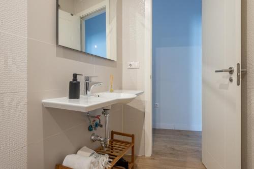 een badkamer met een wastafel en een spiegel bij Puerta Real Centro Apartment in Granada