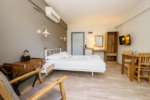 a bedroom with a bed and a desk and a table at Azra Apart & Otel in Gokceada Town
