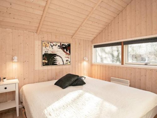 een slaapkamer met een wit bed in een kamer met 2 ramen bij Holiday home Asaa V in Aså