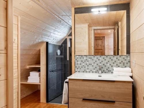 une salle de bain avec un lavabo et un grand miroir dans l'établissement SUNWEB - Les Chalets de L'Ecrin, à La Joue du Loup