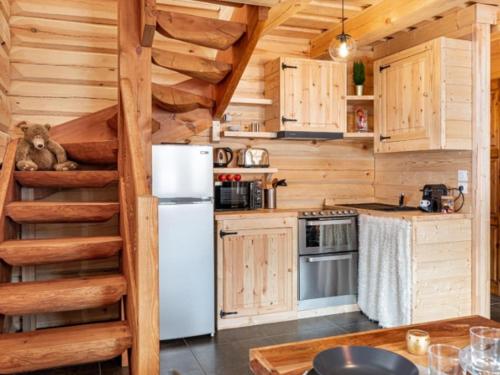 une cuisine avec un réfrigérateur blanc et un escalier dans l'établissement SUNWEB - Les Chalets de L'Ecrin, à La Joue du Loup