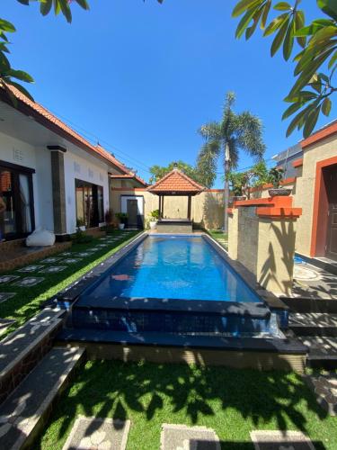 een zwembad in de tuin van een huis bij Villa Margherita in Seminyak