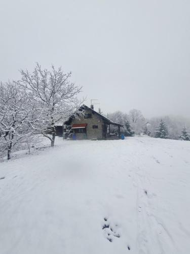 a house in a field covered in snow at Holiday Home Modruš in Modruš