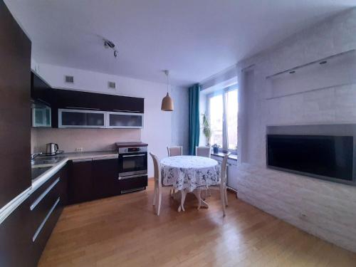 cocina con mesa, fregadero, mesa y sillas en Apartament Rokosowska en Varsovia