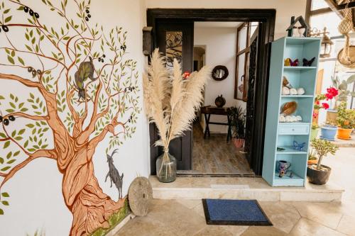 a hallway with a tree mural on the wall at Azra Apart & Otel in Gokceada Town