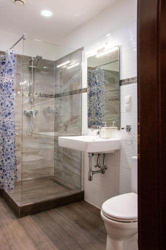 a bathroom with a sink and a shower and a toilet at Vienna Boutique - Premium Hostel in Vienna