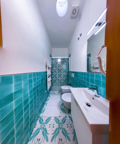 a bathroom with two toilets and a sink and blue tiles at Villa Egidio in Ischia