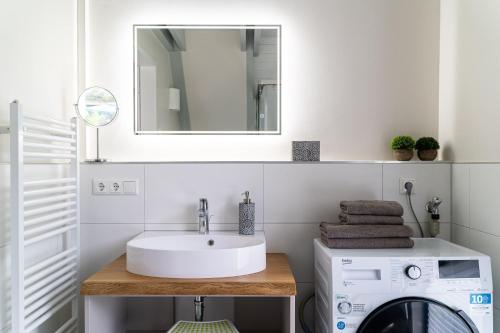a bathroom with a sink and a washing machine at Haus Strandflieder - Domizil am Ostseewald in Zingst