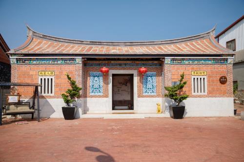 a brick building with a chinese roof at 新龍頭古厝行館 Shin Long Tou B&B in Jinning
