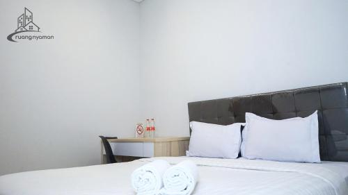 a bedroom with a bed with two white towels on it at Regentown Near ICE BSD in Tangerang