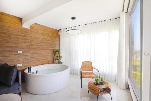 a bathroom with a large tub and a chair at צימר על הים גקוזי ואירוח איכותי Oceanfront Beach House W Jacuzzi in Haifa