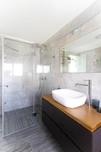 a bathroom with a white sink and a shower at צימר על הים גקוזי ואירוח איכותי Oceanfront Beach House W Jacuzzi in Haifa