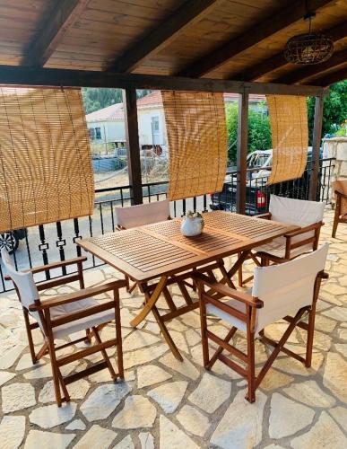 una mesa de madera y sillas en un patio en Helen s house, en Komílion
