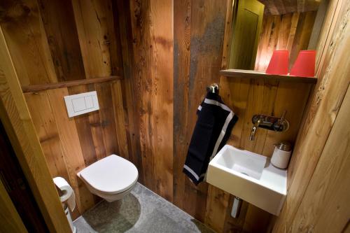 a wooden bathroom with a toilet and a sink at Chalet Z'Gogwärgji in Zermatt