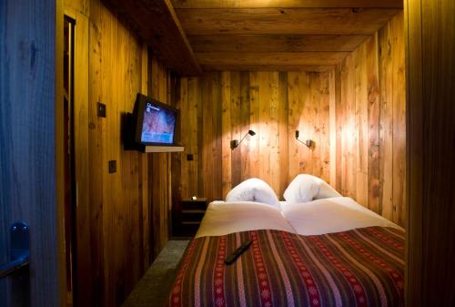 a bedroom with a bed with a television in it at Chalet Z'Gogwärgji in Zermatt