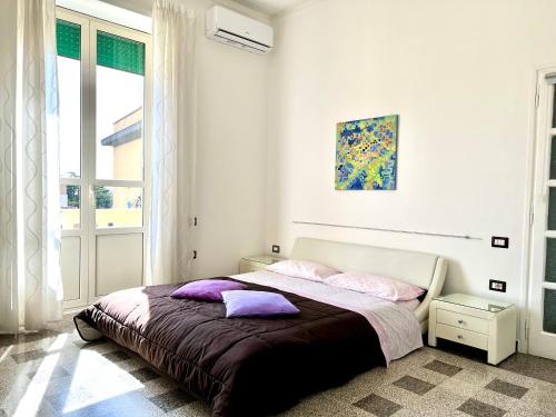 1 dormitorio con 1 cama grande con almohadas moradas en Camera matrimoniale privata in appartamento condivisibile en Salerno