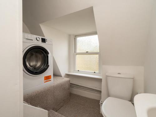 a bathroom with a washing machine and a toilet at Pass the Keys Spacious 3 bed apartment in prime central location in Bath