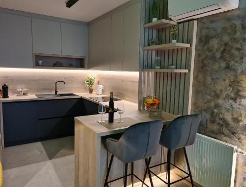 a kitchen with two bar stools and a sink at Wellness Apartments in Varaždin