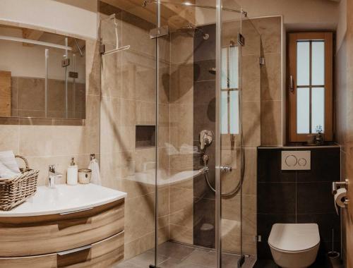 a bathroom with a shower and a sink and a toilet at Ferienhaus Bergler Hoamat in Navis