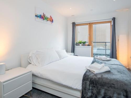 1 dormitorio con cama blanca y ventana en Pass the Keys Spacious 1 Bedroom Apartment in Heart of the City, en Cardiff