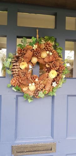 a wreath of fruits and vegetables on a blue door at La petite maison in Le Bosc-Roger-en-Roumois