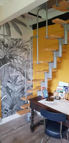 an office with a desk with a staircase and a mural at La petite maison in Le Bosc-Roger-en-Roumois
