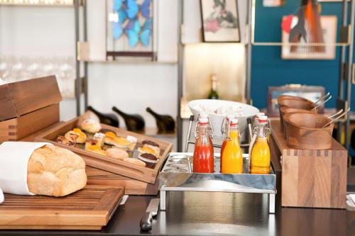 einen Tisch mit einem Tablett mit Brot und Saucenflaschen in der Unterkunft Vesper Hotel in Noordwijk aan Zee